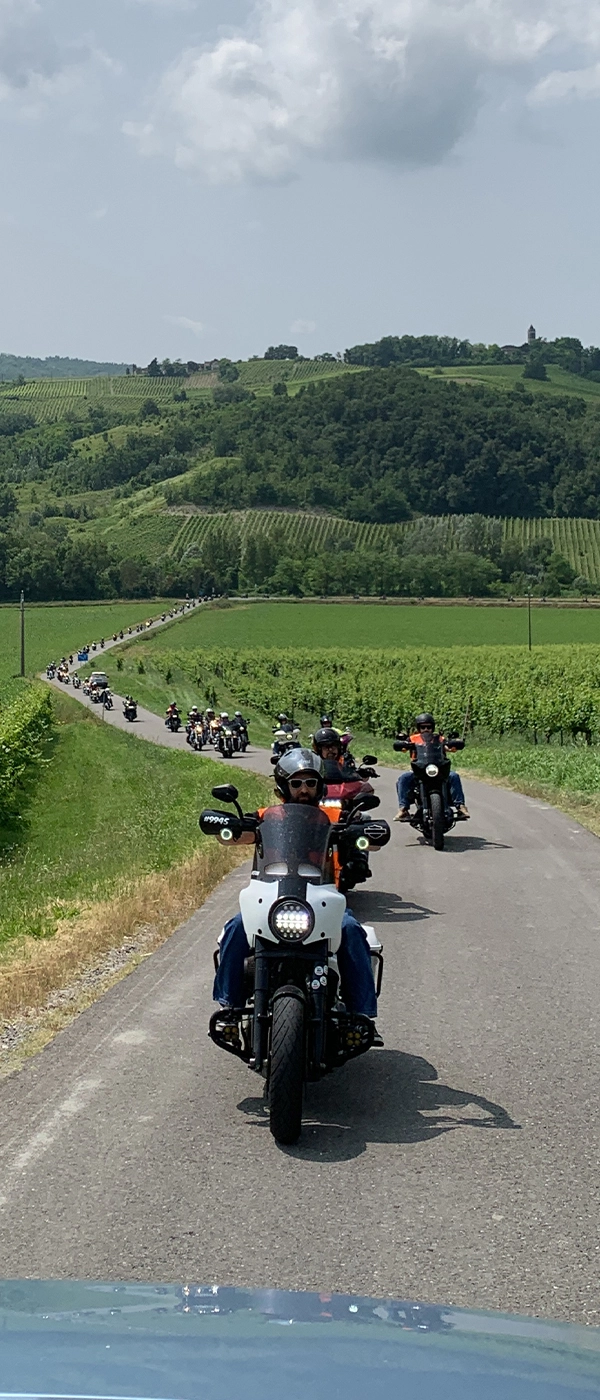 Scatto della lunga fila di Harley su strada durante l’Anello Divino